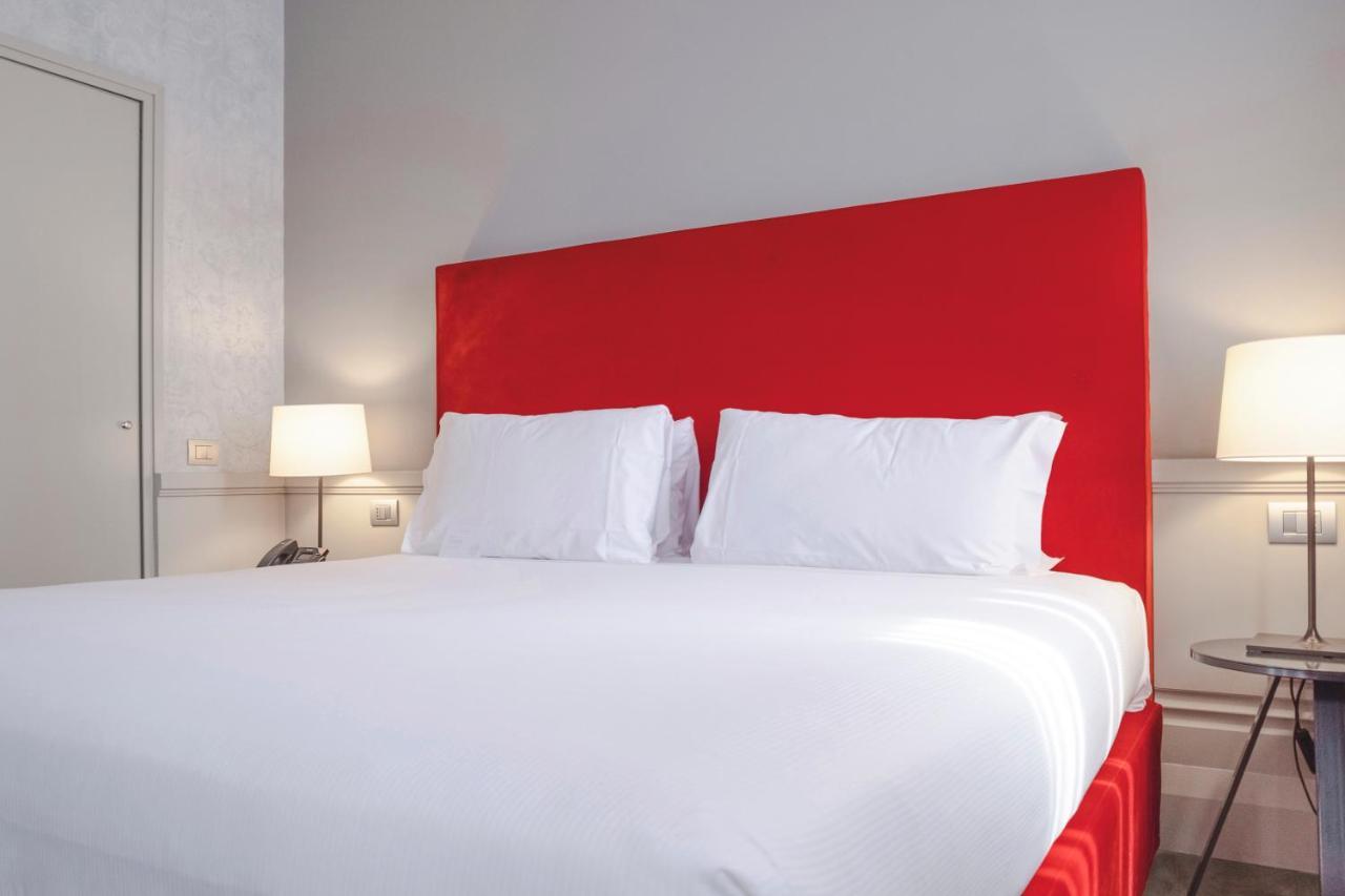 Palazzo Cornalia Hotel Milánó Kültér fotó A bed with a red headboard